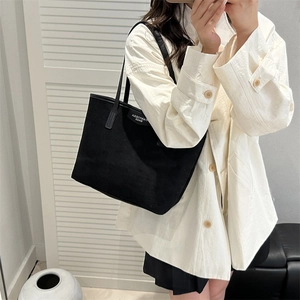 Minimalist black faux suede large tote bag with shoulder straps shown on a model