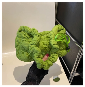 Detail of lime green quilted shoulder bag showing pleated texture and side drawstring