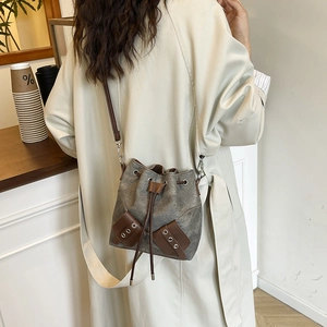 Chic grey canvas bucket bag with brown leather trim and drawstring for women