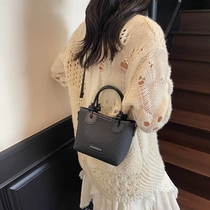 Fashionable black bucket bag with a stylish logo label and versatile crossbody strap