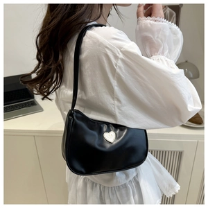 Detail of black PU leather shoulder bag featuring a silver metal heart-shaped logo accessory