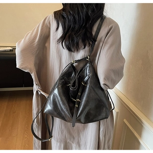 Detail of a large black vintage leather bucket bag with a slim adjustable shoulder strap