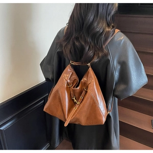 Brown vintage leather backpack featuring unique geometric folds and gold metal buckle