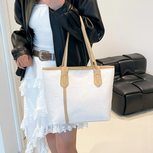 White leather tote bag with heart embossed pattern and khaki shoulder straps for women