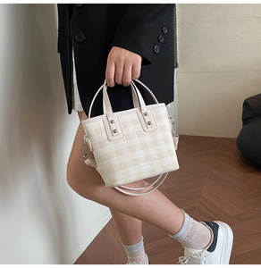Detail der karierten Beuteltasche mit Metallnieten und TIANYUN YICAI Logo