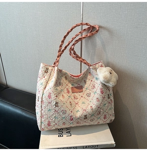 Detail of floral tote bag with pink woven handles and cute white plush bear charm accessory