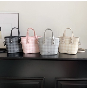 Detail view of mini gingham bucket bags in black, pink, grey and beige with logo details