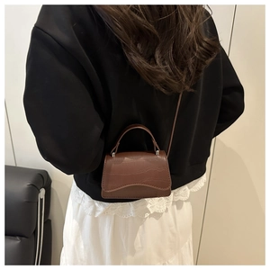 Vue détaillée du mini sac bandoulière marron à motif crocodile sur un mannequin