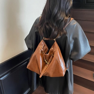 Vintage brown leather backpack with triangular fold design and gold hardware for women