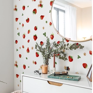 Close-up of strawberry wall stickers with flowers on a white wall in a cozy room