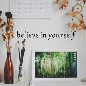 Macro shot of 'Believe in yourself' wall sticker in a cozy home office setting