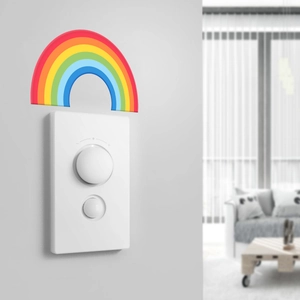 Close-up of a white smart dimmer switch with rainbow decor on a modern grey wall