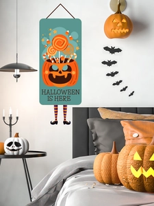 Detail of Halloween door hanging with pumpkin candy bucket and decorative striped legs