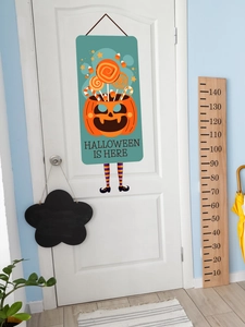 Detail of Halloween door hanging with pumpkin candy bucket design and striped witch legs