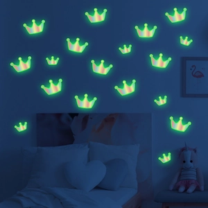 Luminous crown wall stickers glowing green in a dark bedroom for kids room decor
