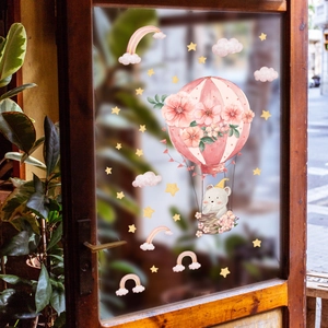 Cartoon elephant and hot air balloon static window decals on a wooden glass door
