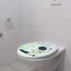 Glow-in-the-dark astronaut toilet sticker with a funny 'clean your piss' slogan