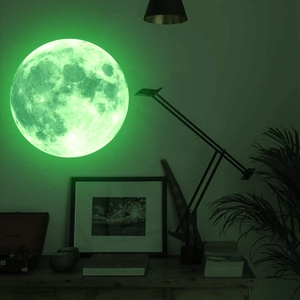 Luminous moon wall sticker showing glowing green texture and craters in dark room