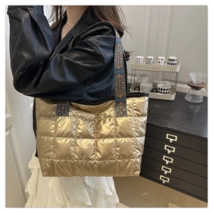 Quilted gold space cotton tote bag with ethnic pattern straps shown on shoulder