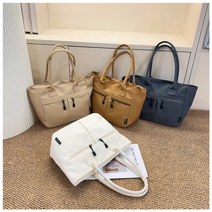 Detail of four colorful canvas tote bags featuring multiple zipper pockets and fabric handles