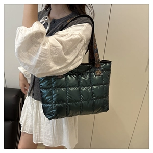 Dettaglio della borsa tote trapuntata verde scuro con tracolla in tessuto stile etnico