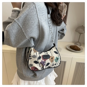 Detailed shot of vintage floral jacquard crescent bag with silver chain strap and leather trim