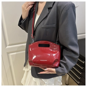 Detail of red patent leather bucket bag with white Fashion & Bags text and top handle