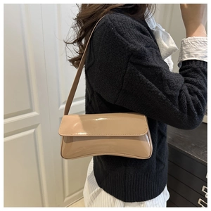 Close-up of beige patent leather shoulder bag showing glossy texture and flap design
