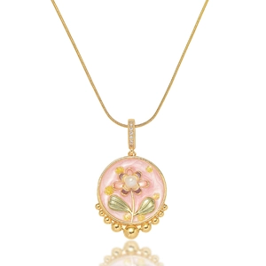 Macro shot of gold floral enamel necklace with pink petals and freshwater pearl inlay