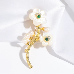 Broche florale en nacre avec perles blanches et zircon vert sur fond de soie