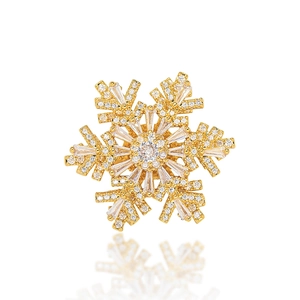 Rotating snowflake brooch with sparkling cubic zirconia and gold finish in a 3D design