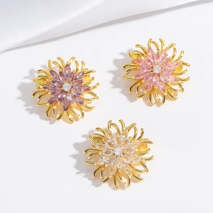 Lot de trois broches marguerites en cristal aux tons violet, rose et or blanc