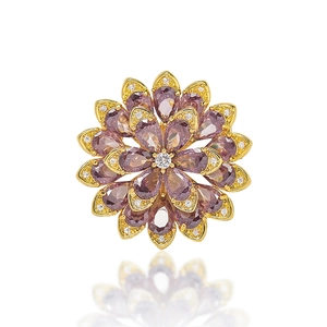 Elegant gold daisy brooch featuring purple pear-cut crystals and sparkling white zircon accents