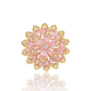 Close-up of crystal daisy brooch with pink pear-shaped zircon petals and gold plating