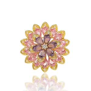 Detailed close-up of crystal daisy brooch with pink and purple pear-cut gemstones