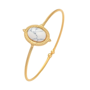 Détail d'un bracelet ouvert doré avec turquoise blanche ovale et bande torsadée