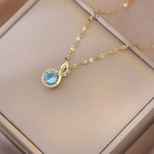 Elegant gold musical note necklace with blue zircon pendant and sparkling crystal halo