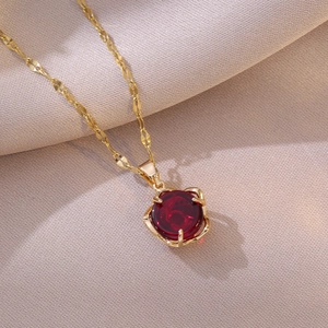 Elegant gold titanium necklace featuring a red rose flower zircon pendant on silk background