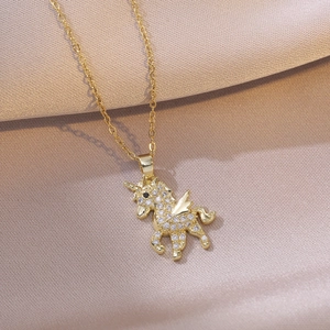 Goldene Einhorn-Halskette mit Zirkonia auf elegantem champagnerfarbenem Satinhintergrund