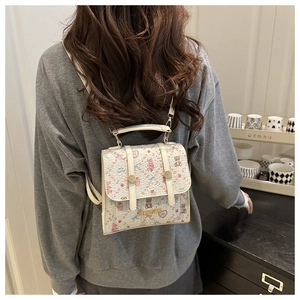 Close-up of a floral mini backpack with cute patterns held in a warm lifestyle setting