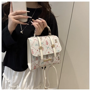 Detail of cartoon bear print mini backpack with metal buckle and gold nameplate