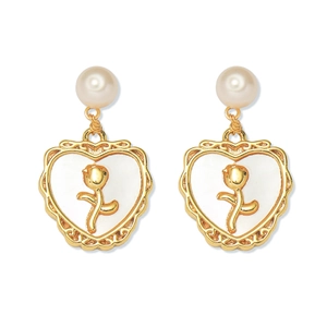 Detailed view of heart-shaped earrings with gold rose and white enamel finish