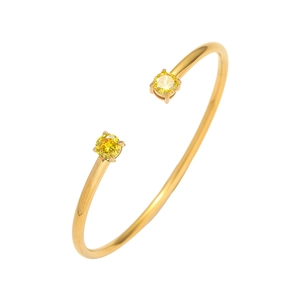 Dettaglio del bracciale aperto dorato con zirconi cubici gialli e castone a quattro griffe