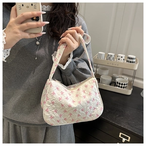 Dettaglio della borsa a spalla bianca arricciata con fiocchi rosa e chiusura a zip