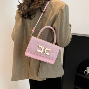 Pink underarm shoulder bag with shimmering flap and gold buckle on a model