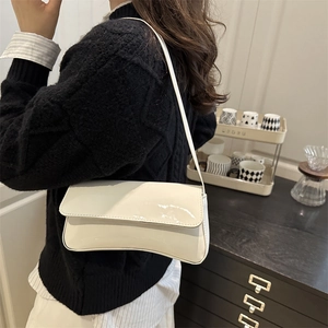 Chic white patent leather baguette shoulder bag with minimalist flap design and glossy finish