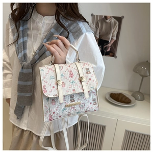Floral backpack with cute rabbit prints shown held by a model in a cozy indoor setting