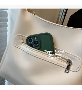 Detail of exterior zipper pocket on cream tote bag showing large capacity for smartphone