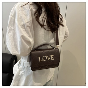 Détail du sac bandoulière matelassé marron foncé avec lettrage LOVE en métal doré