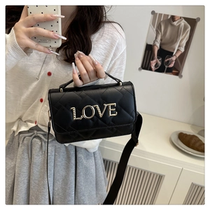 Détail du sac bandoulière noir matelassé avec logo LOVE doré et large bandoulière